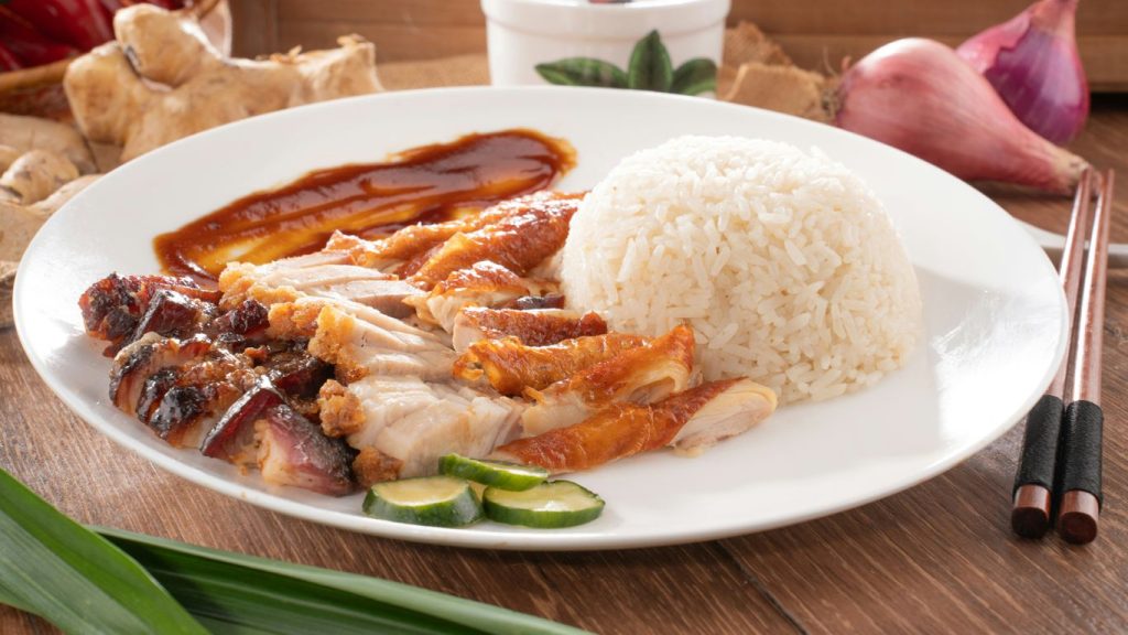 Here's a caption: delicious roasted duck and rice dish on a plate.